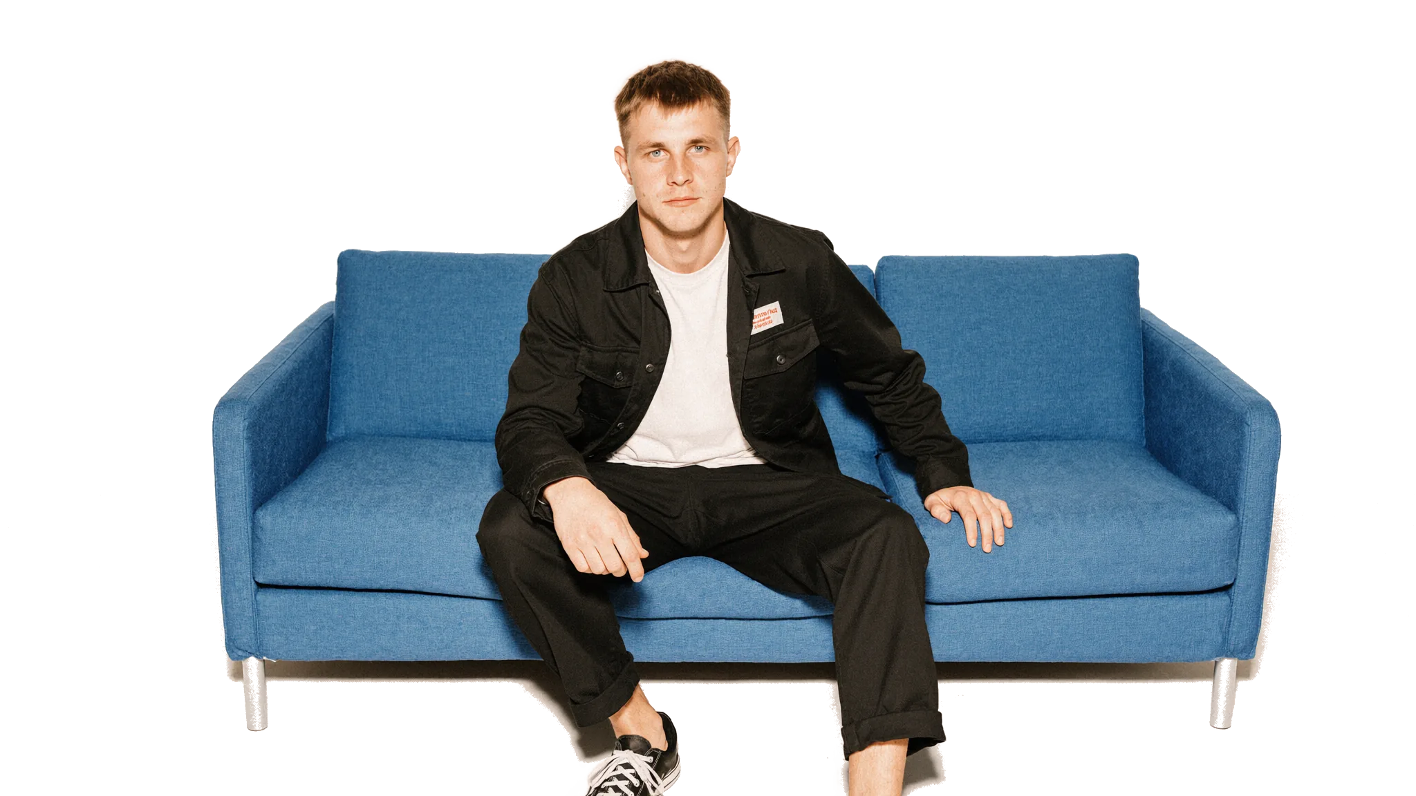 Dovydas sėdi ant mėlynos sofos